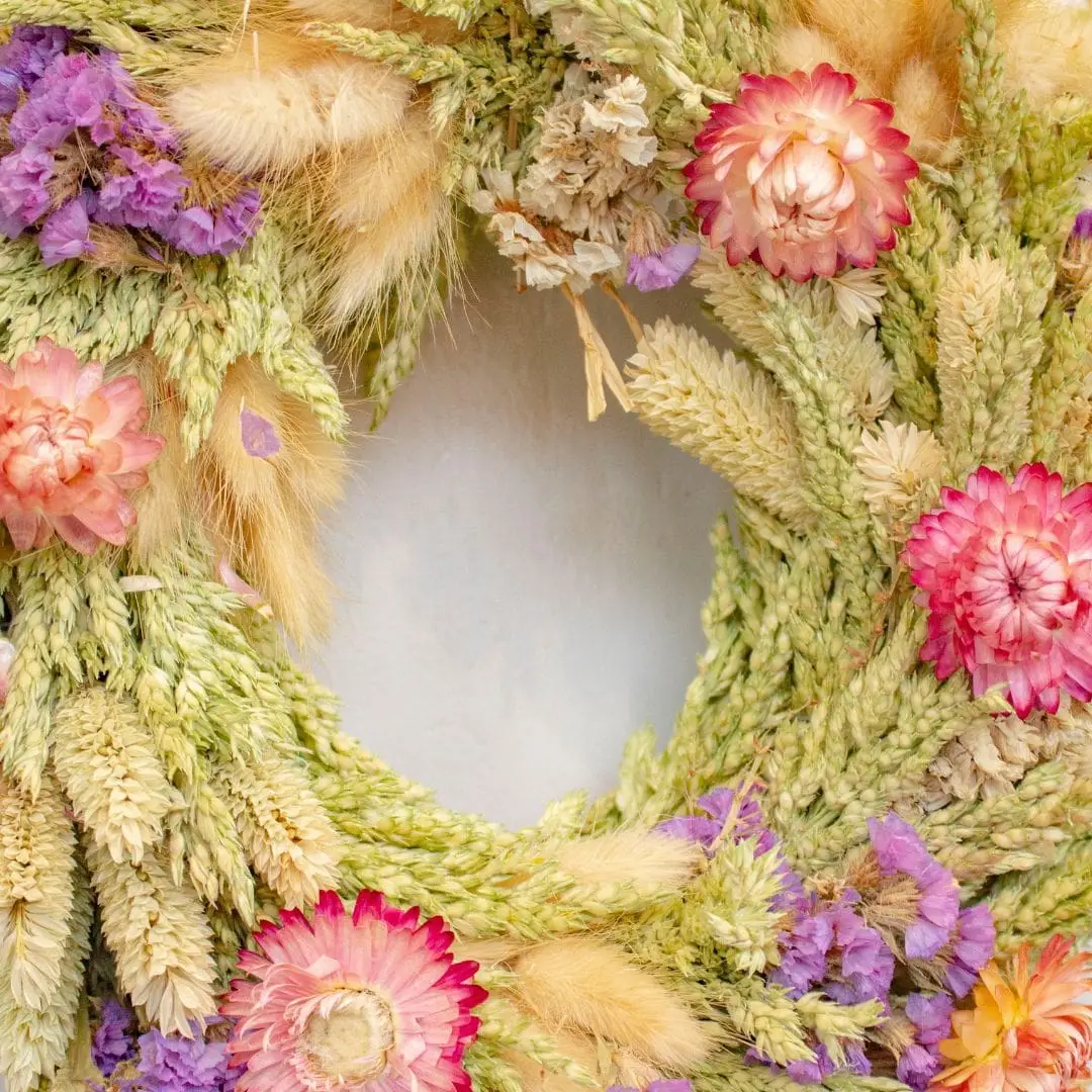 Couronne de fleurs séchées au ton vert violet et rose pour décorer son intérieur ; décoration original d'intérieur