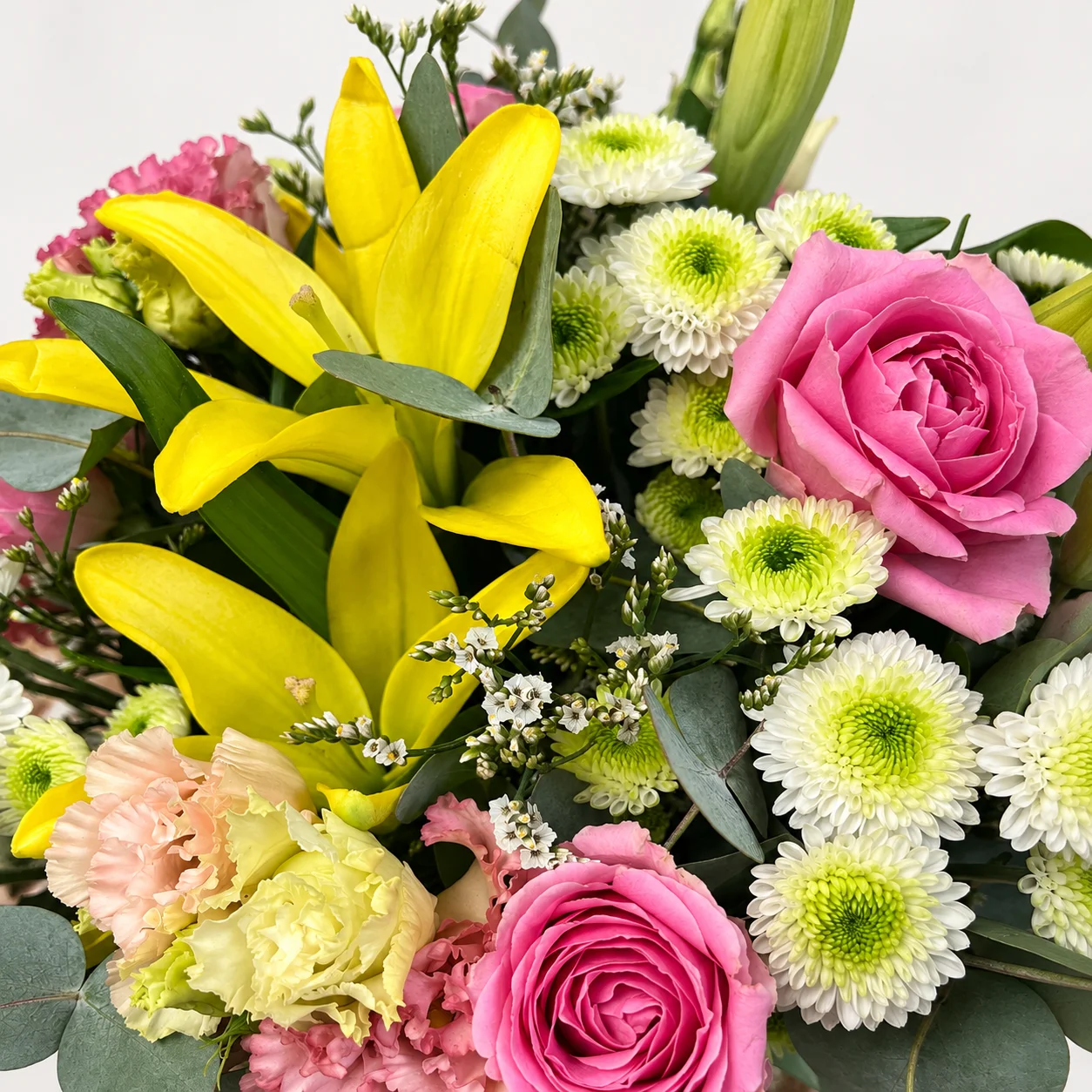Gros plan des lys jaunes, roses roses et petites fleurs blanches du bouquet à prix canon
