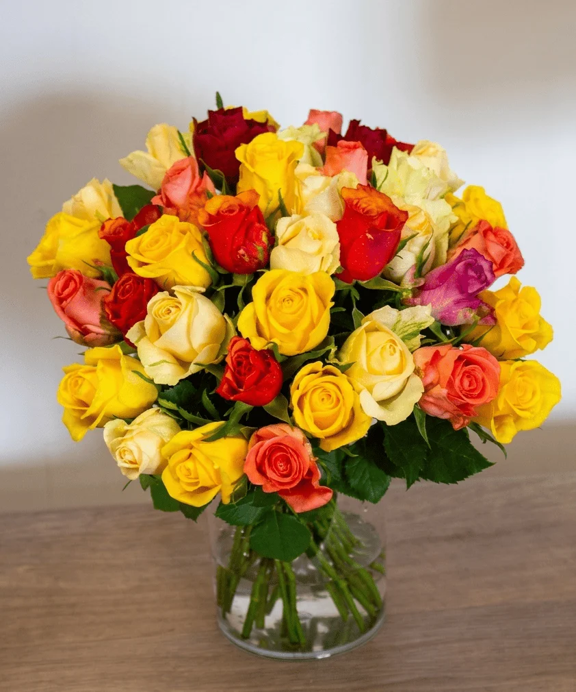 Bouquet de roses multicolores dans un vase transparent