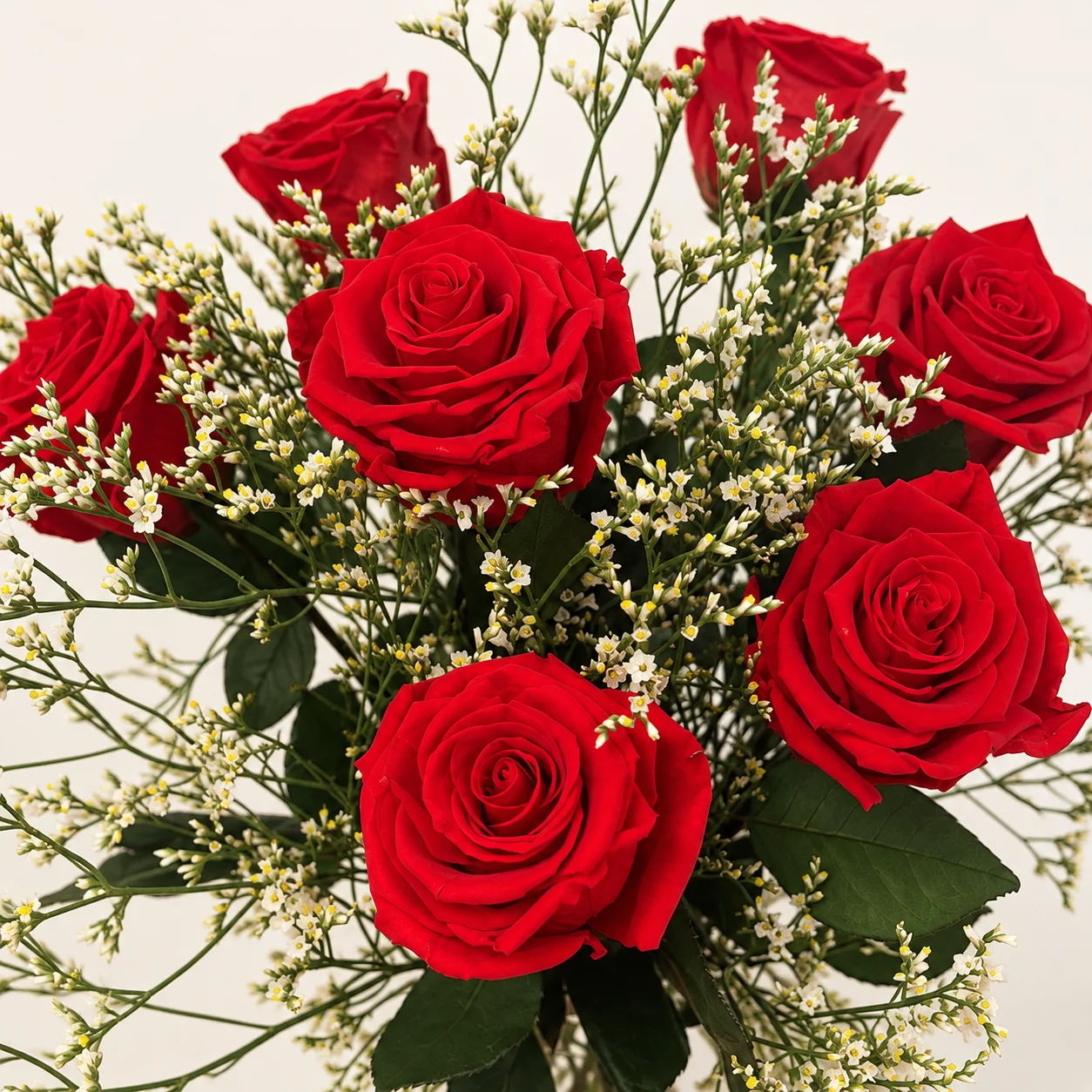 Détail des roses rouges stabilisées et des petites fleurs séchées claires